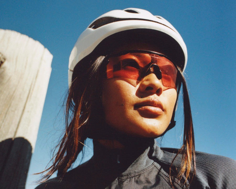Person wearing a helmet and sunglasses with a clear blue sky background